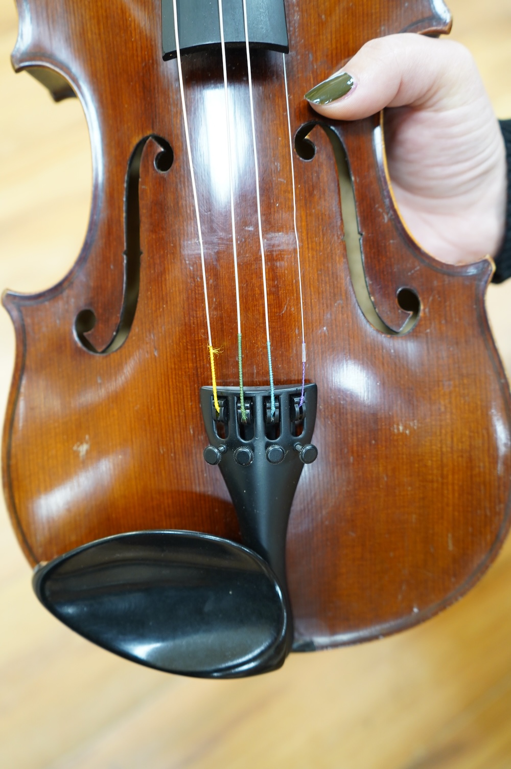 An early 20th century German violin, with a label reading ‘Copy of Joseph Guarnerius, Made in Germany’, body length 35.5cm, cased with a bow by Tourte. Condition - good.